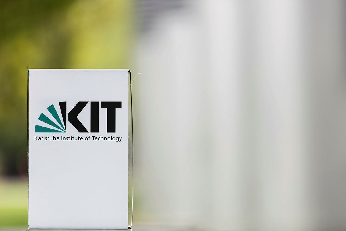 Bühnenbild eines weißen Kartons mit KIT-Logo (Karlsruher Institut für Technologie) im Freien.